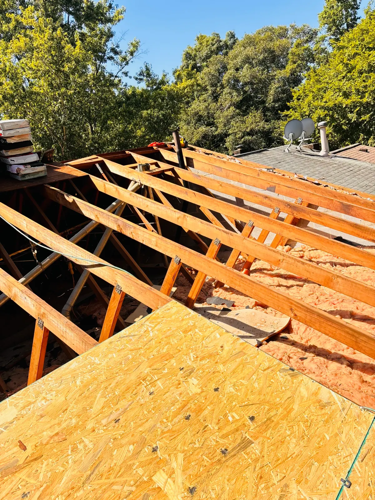 New roof trusses and decking going on during a structural roof rebuild