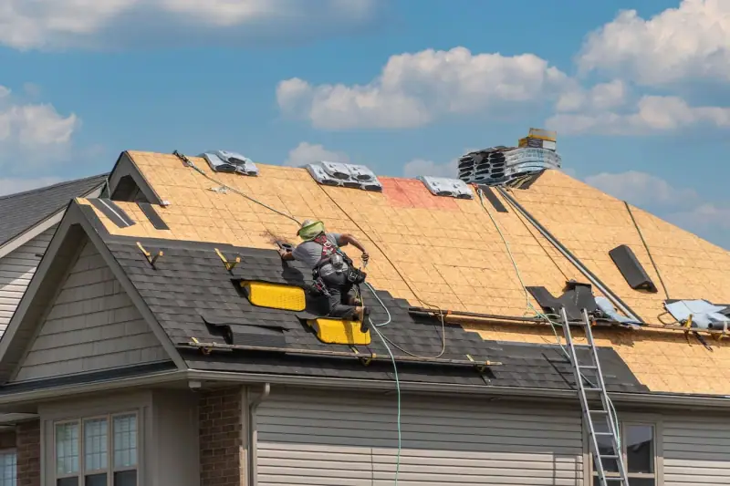 Roofer installing shingles over fresh decking on a residential re-roof